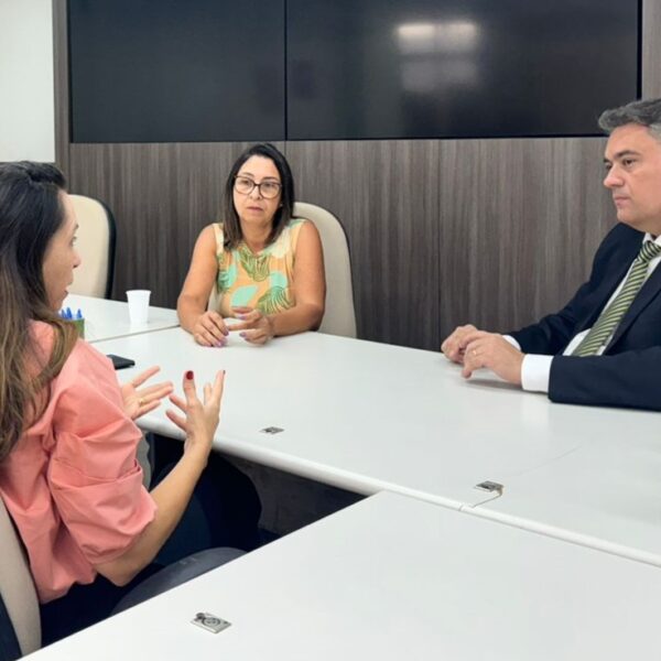 Coordenador do curso de Direito do UniSales, prof. Thyago Brito de Mello, conduzindo uma audiência com duas pessoas em uma sala de ambiente jurídico, durante o mutirão do Projeto Justiça Comunitária.